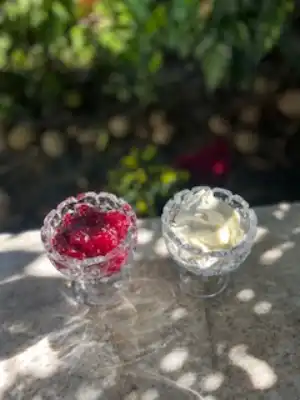 clear glass bowls with clotted cream and strawberries preserves.