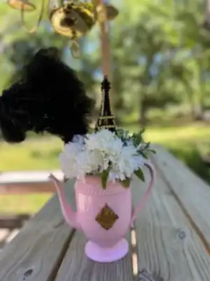 pink teapot with a black feather and a black eiffel tower centerpiece