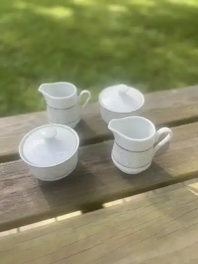 matching china rentals | The Tea Party Company 2 milk and 2 sugar bowls white with silver rim standing on a wood table