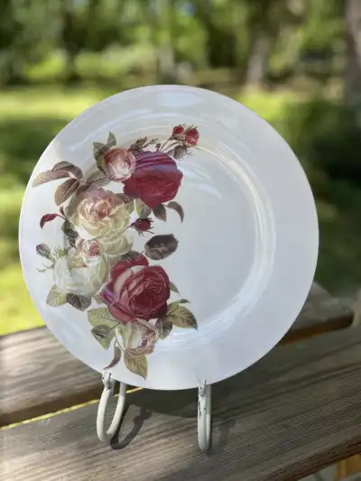dinner plates rentals | The Tea Party Company White dinner plate with some yellow and red roses on one dide.