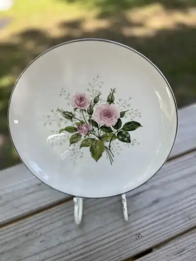 dinner plates rentals | The Tea Party Company Standing on a metal base is a dinner plate vintage style cream with some pink roses in the center.