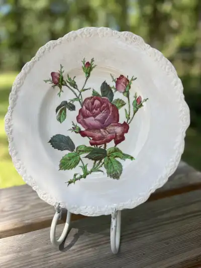 dinner plates rentals | The Tea Party Company Really pretty plate cream color with a rose in the middle The edge is in a scallop shape.
