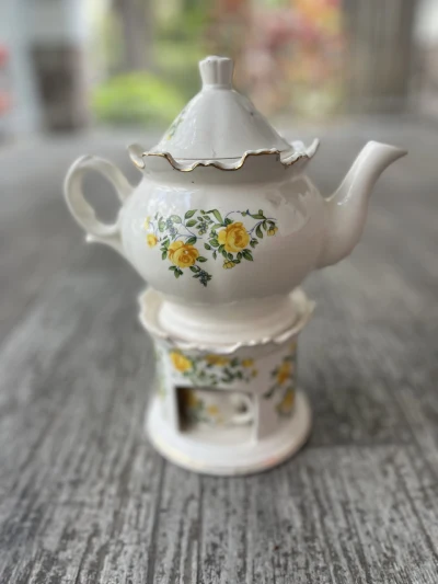 mismatch china rentals | The Tea Party Company Beautiful white tea[[pot with yellow flowers sitting on a matching porcelain teapot warmer