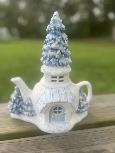 mismatch tea pots rentals | The Tea Party Company All white and blue christmas teapot with a tall tree on the lid and a door and a window.