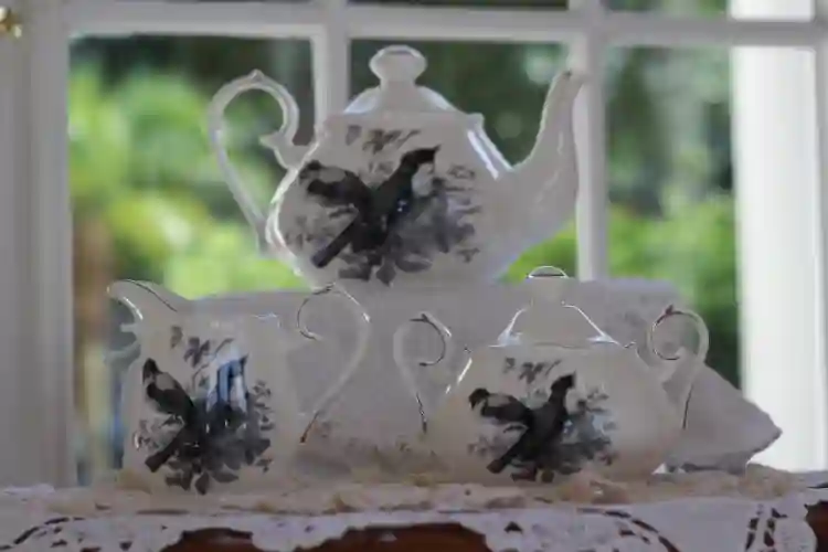 white teapot creamer and sugar bowl black birds motif