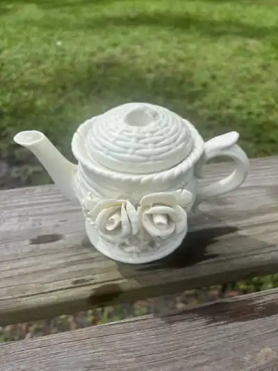 White porcelain teapot with 3d roses in the middle.