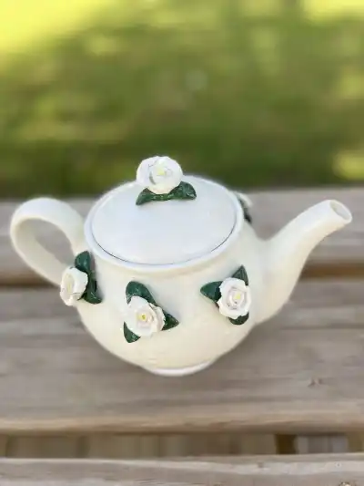 White teapot with 3d white roses on lid and around.